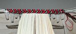 Finished Armenian-style endband, view from fore edge, with thick cord and linen thread primary (tiedowns through the boards) and red, black, and white silk secondary (with two additional cores).