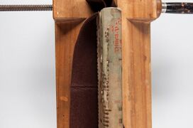 Sections of a polyester and paper laminate inserted under vellum for spine repair